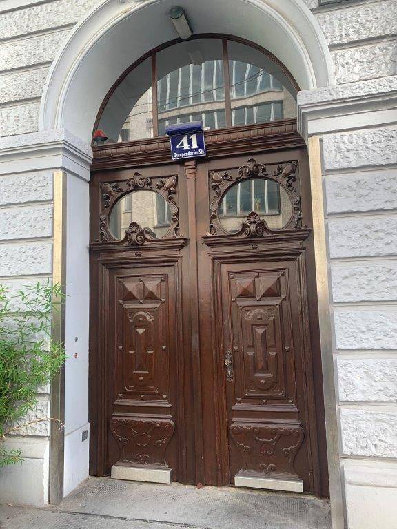 Prunkvolle, geschnitzte Holztür als Eingang eines historischen Gebäudes mit Hausnummer 41.