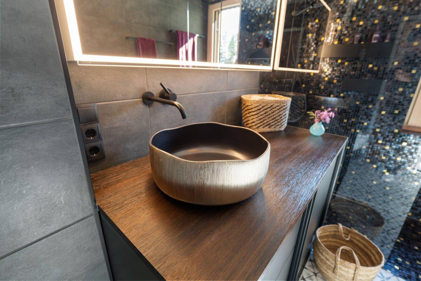 Detailansicht des modernen Waschbeckens auf einer Holzplatte im stilvollen Badezimmer.