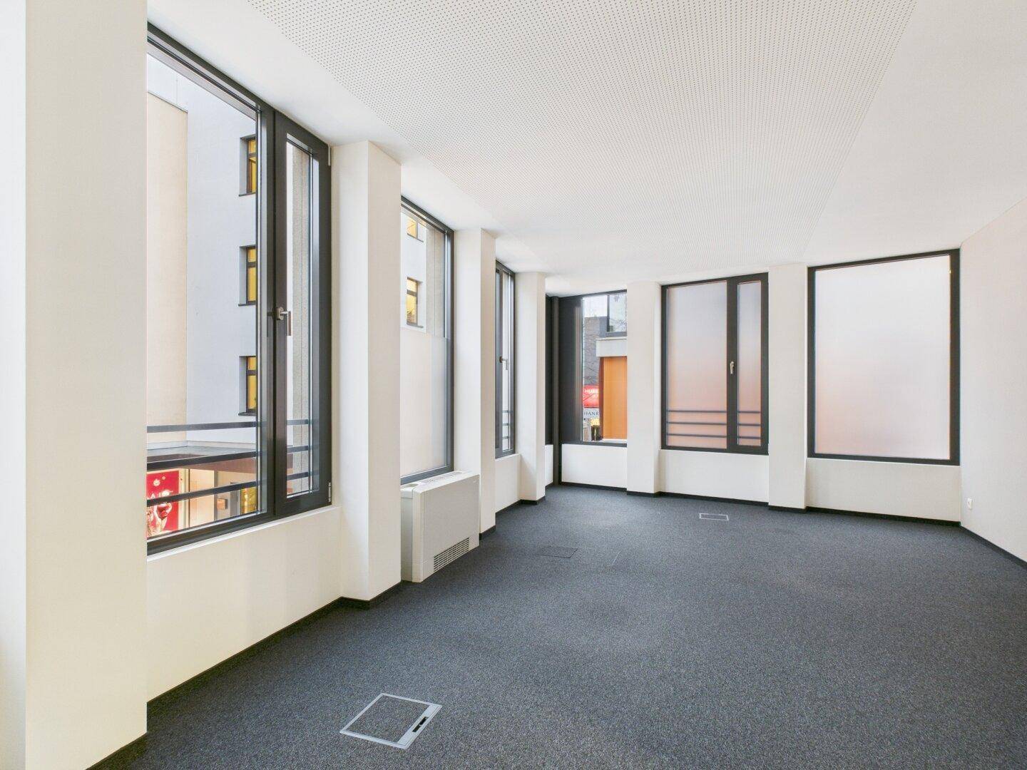 Großes Eckbüro mit zahlreichen Fenstern, die einen weiten Blick und viel Tageslicht bieten.