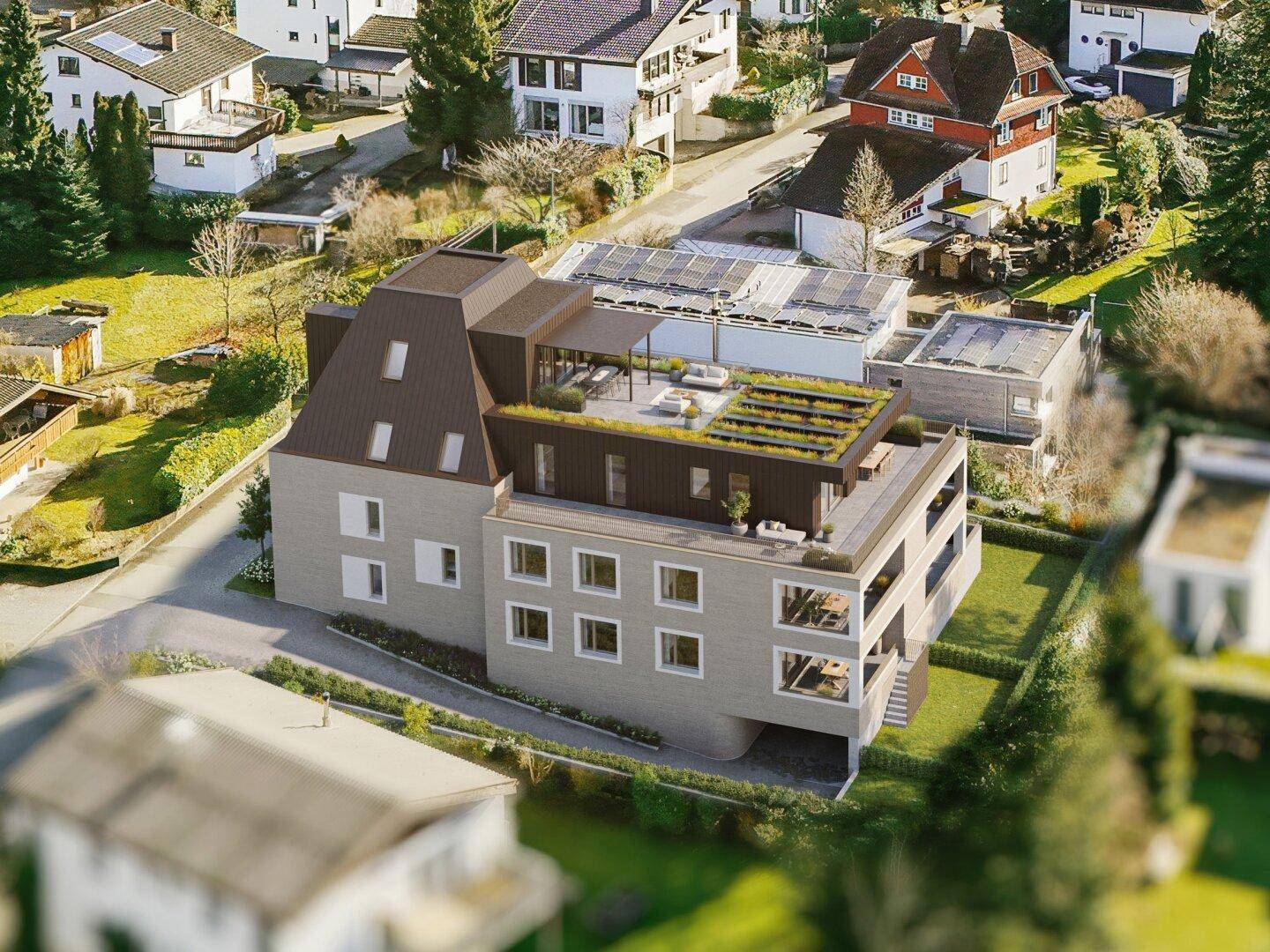 Luftaufnahme der modernen Wohnanlage mit begrünter Dachterrasse und Sitzgelegenheiten.