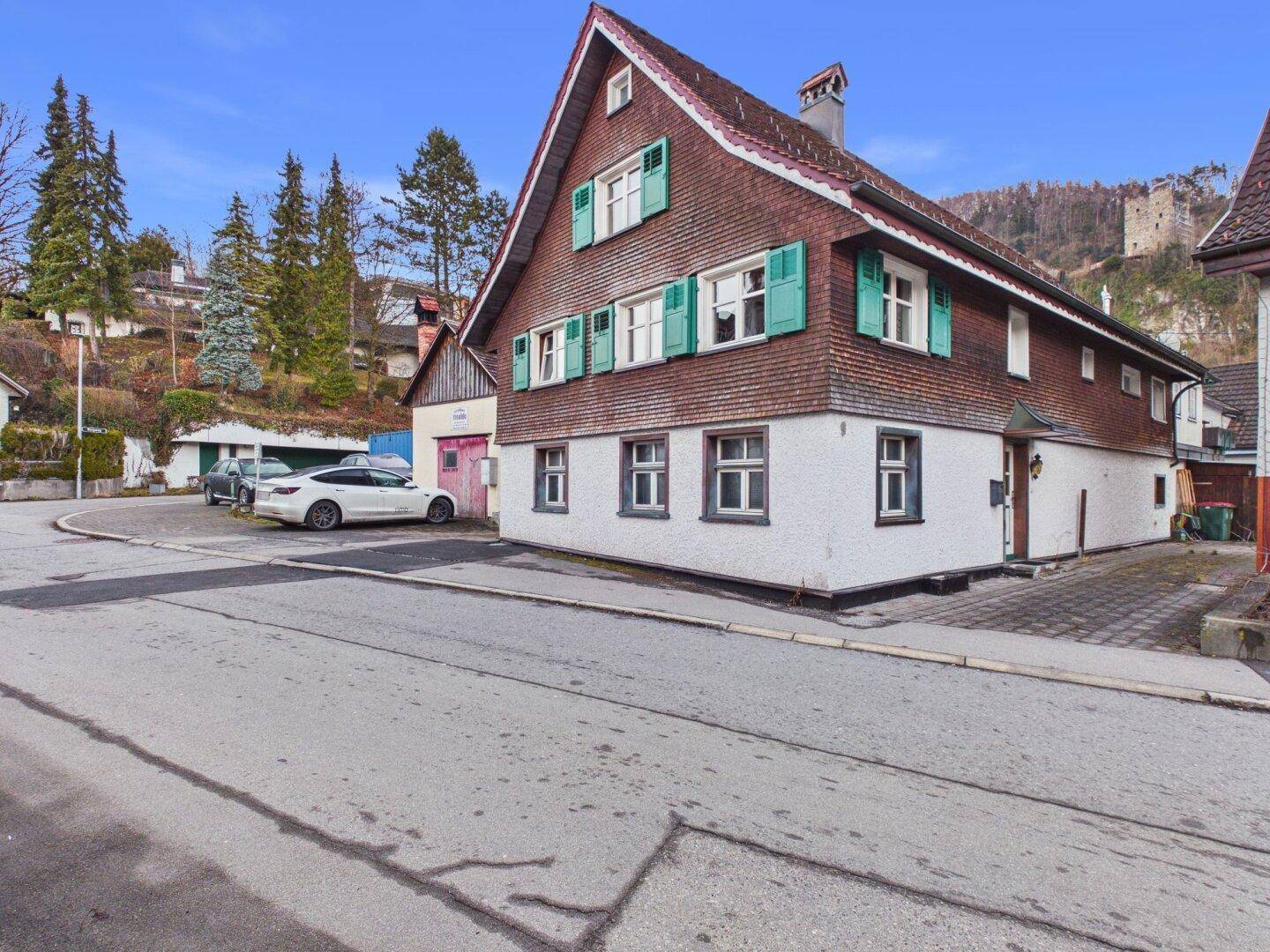 Charmantes traditionelles Haus mit grünen Fensterläden an einer ruhigen Straße gelegen.