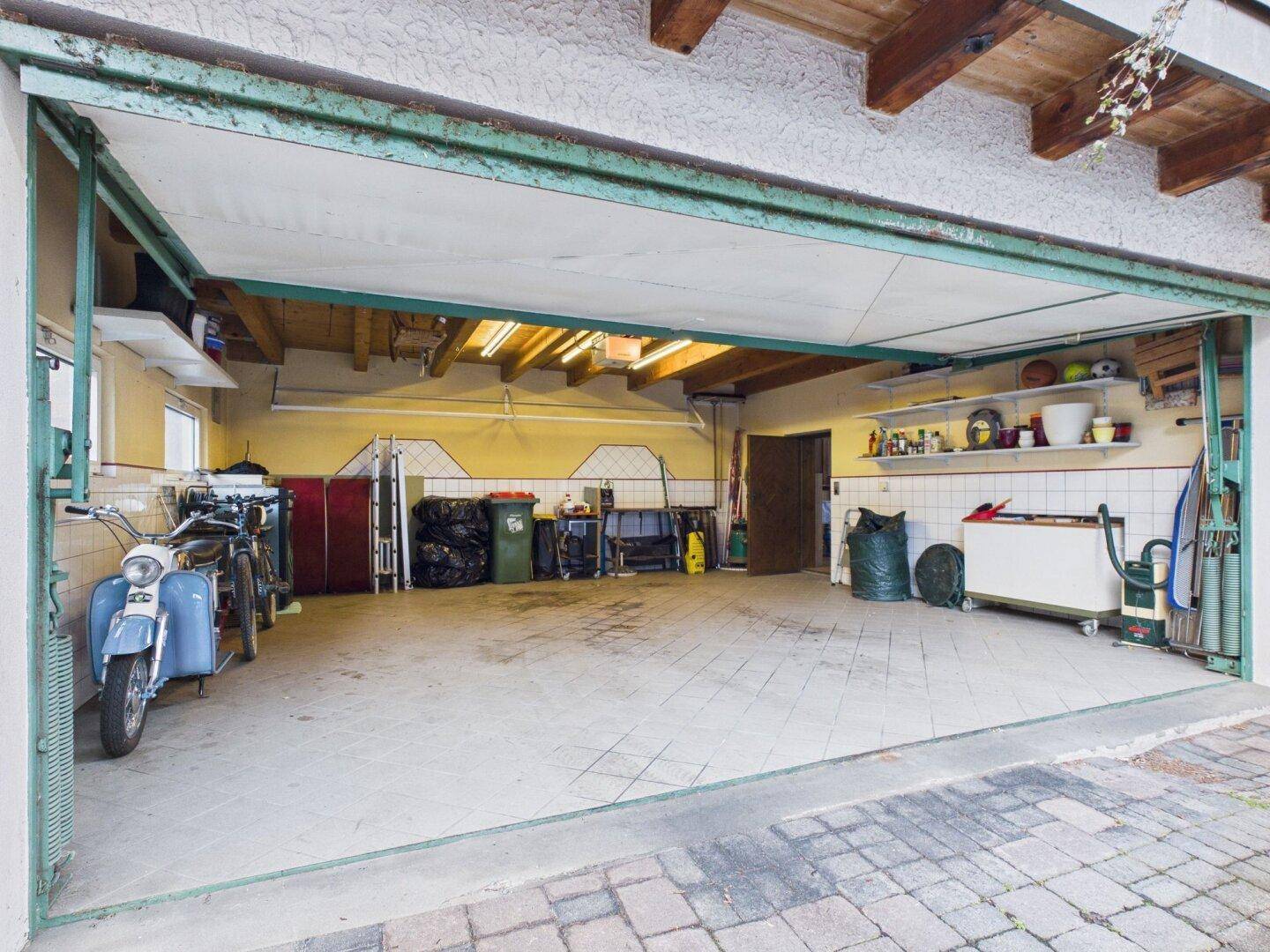 Geräumige Garage mit Betonboden, Stauraum und Platz für Fahrzeuge.