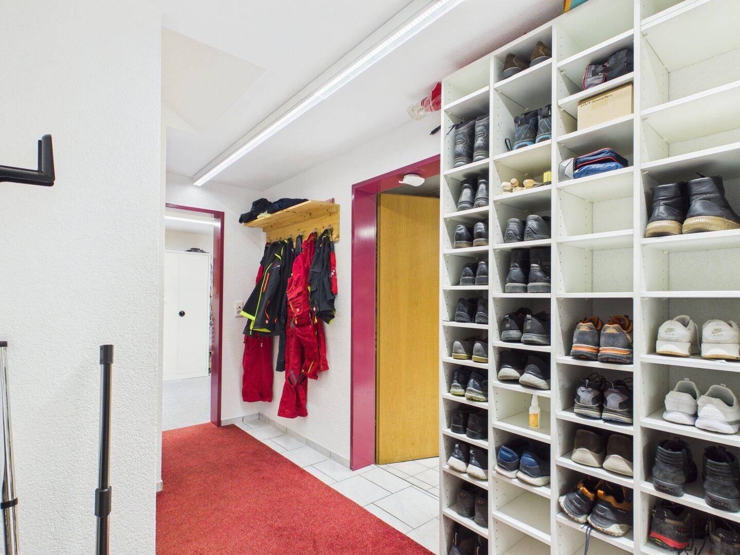 Geräumiger Flur mit großem Schuhregal und Garderobenbereich.