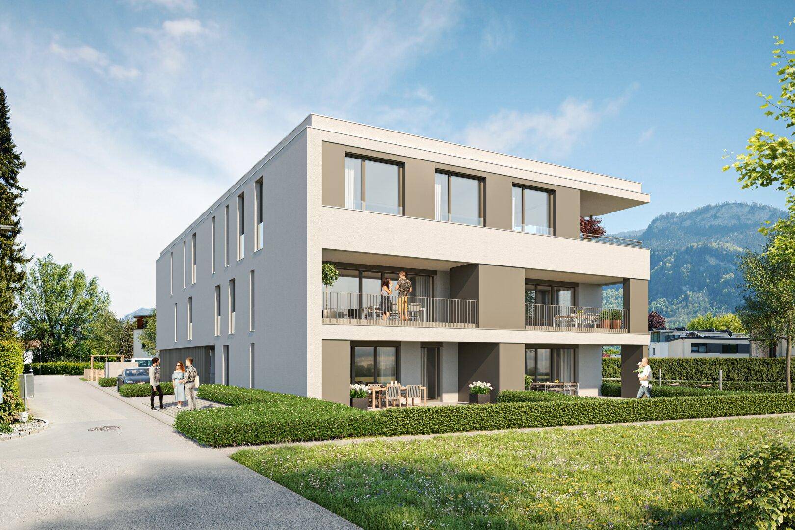 Moderne Architektur eines Neubaus mit Balkonen, Terrassen und Bergblick im Hintergrund.