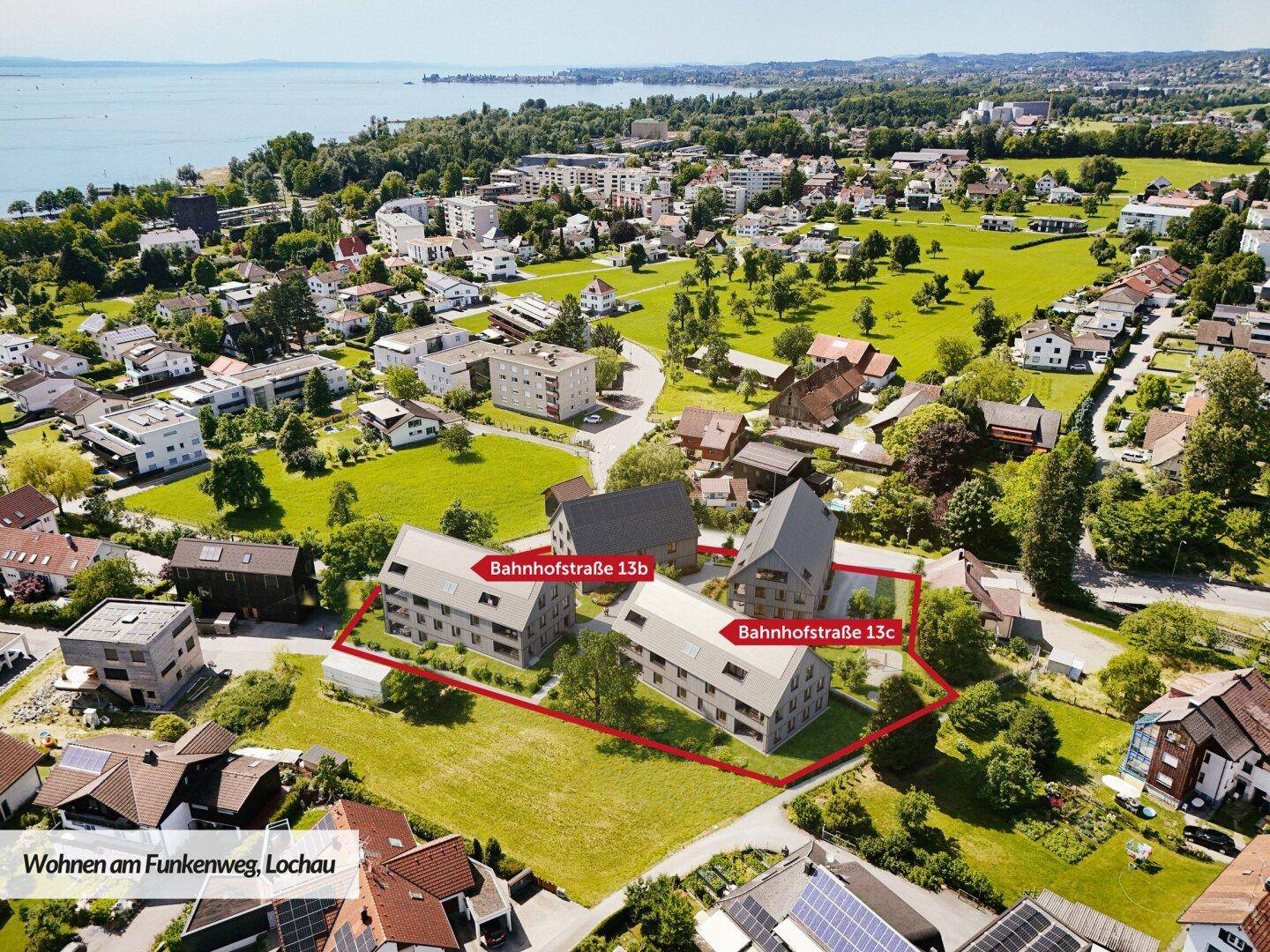 Panoramablick auf die moderne Wohnanlage am Bodensee, umgeben von grünen Wiesen und Wohnbebauung.