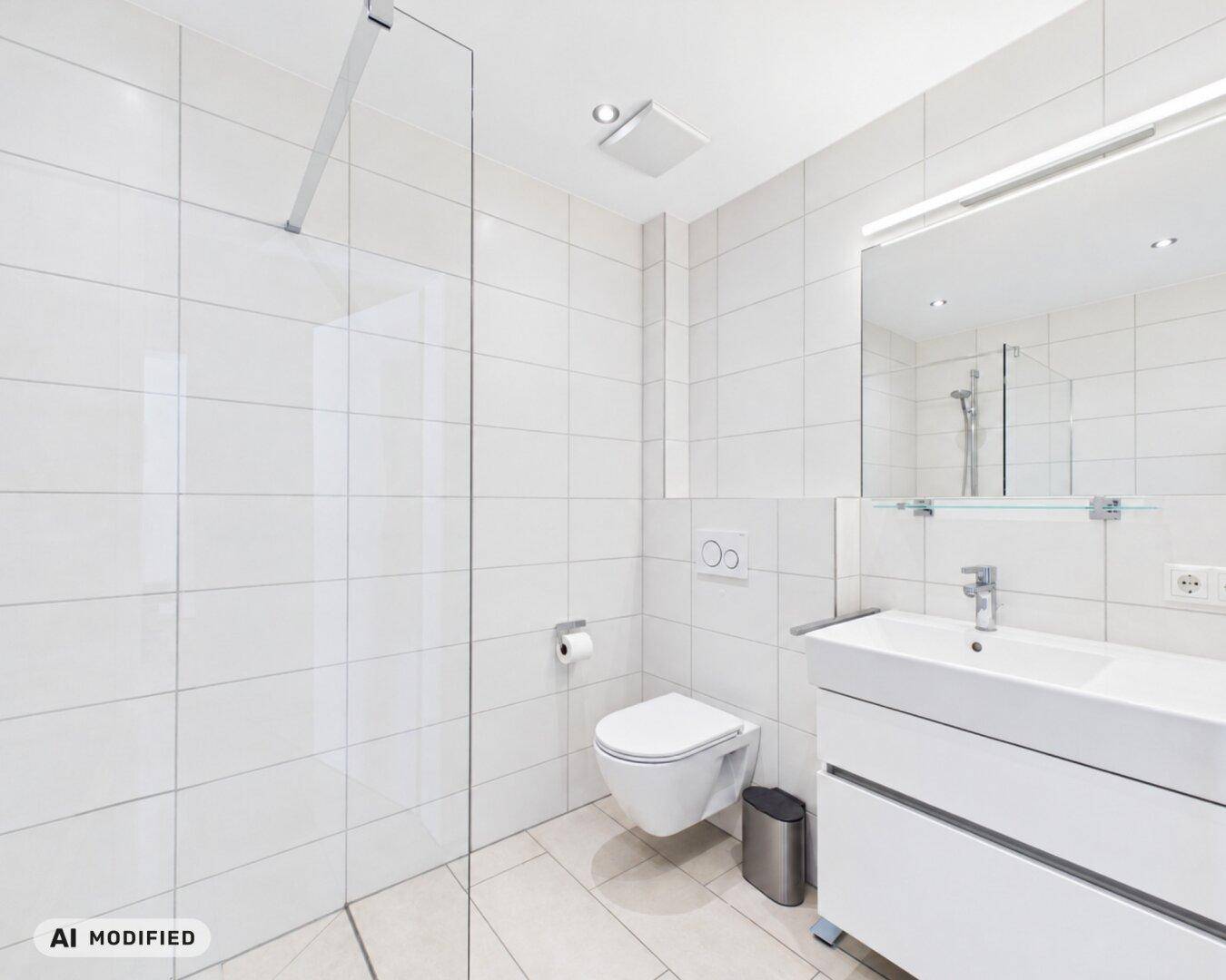 Modernes Badezimmer mit weißen Fliesen, bodengleicher Dusche und wandhängendem WC.