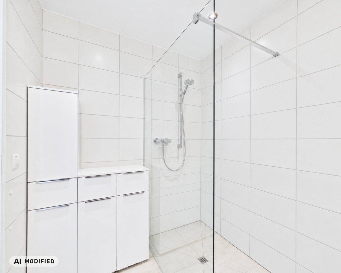 Helles Badezimmer mit großer, ebenerdiger Dusche und weißen Schränken für Stauraum.