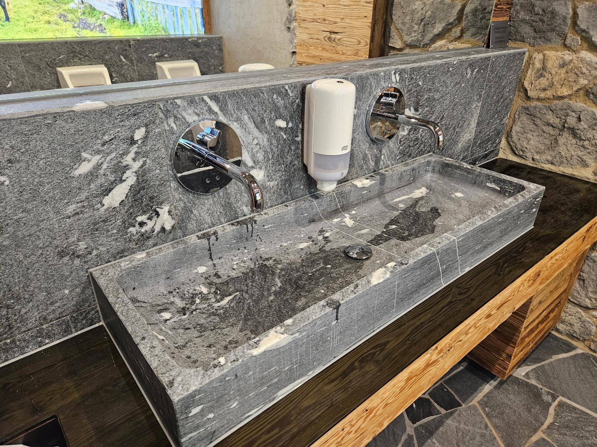 Modernes Badezimmer mit Doppelwaschbecken aus Naturstein und Holzunterschrank in luxuriösem Design.