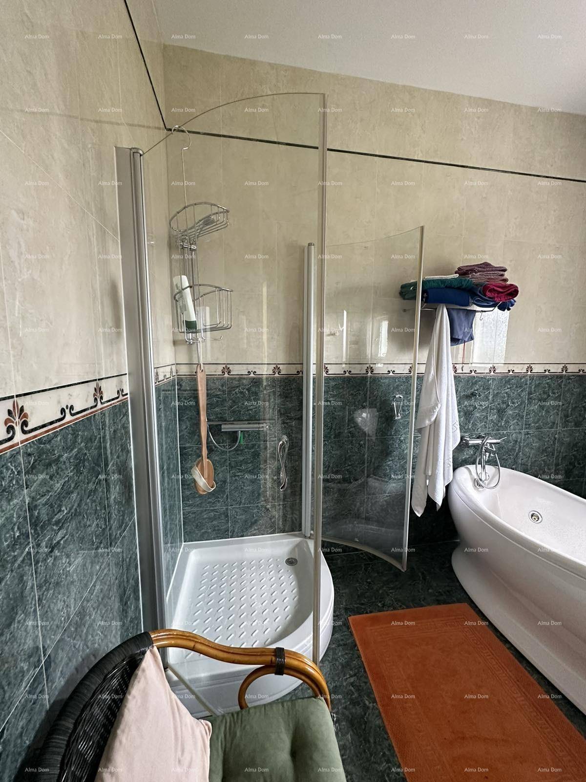 Badezimmer mit Duschkabine, Badewanne und dunkelgrünen Fliesen an den Wänden.