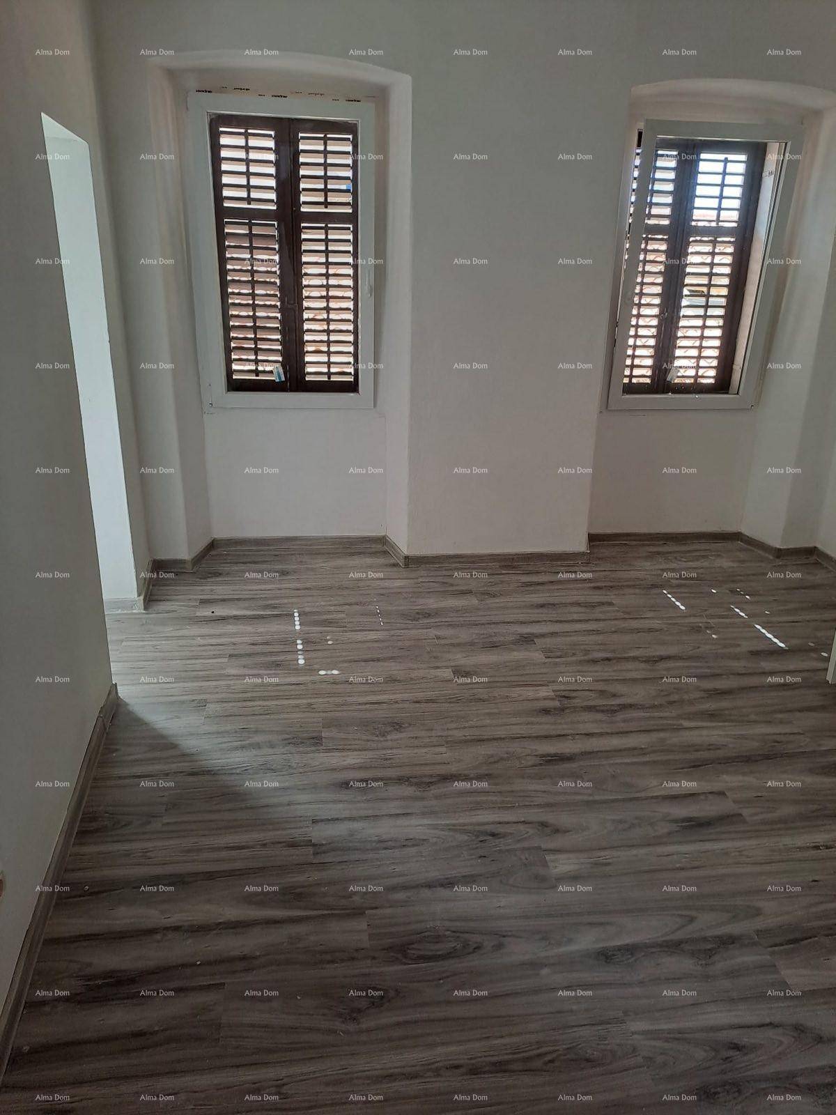 Geräumiges Zimmer mit Laminatboden und geschlossenen Fensterläden, die vor Sonne schützen.