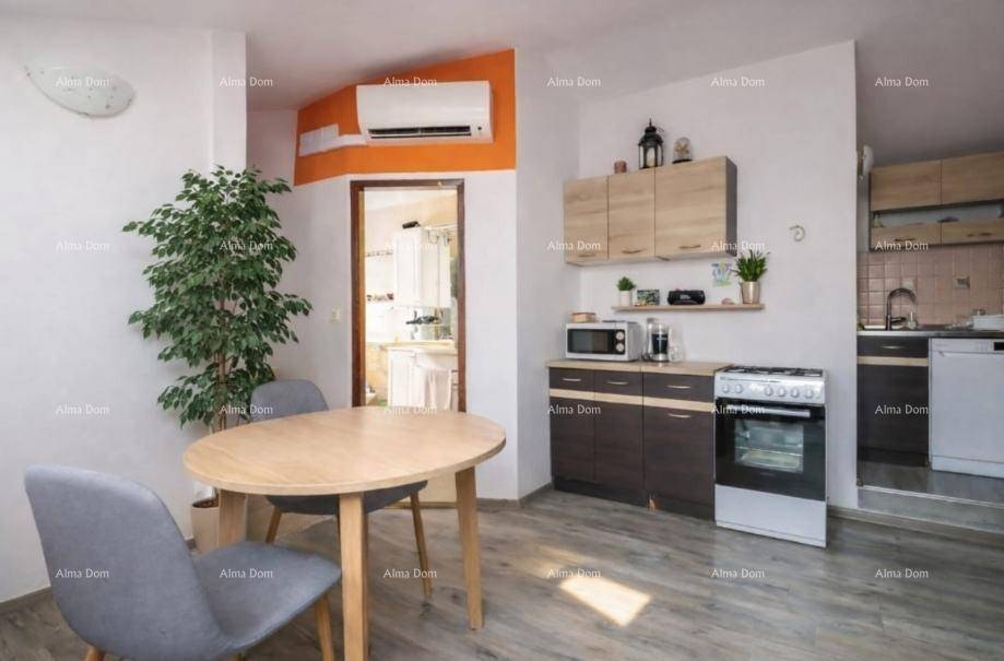 Kompakte Küche mit Essbereich, Klimaanlage und moderner Ausstattung in hellem Design.