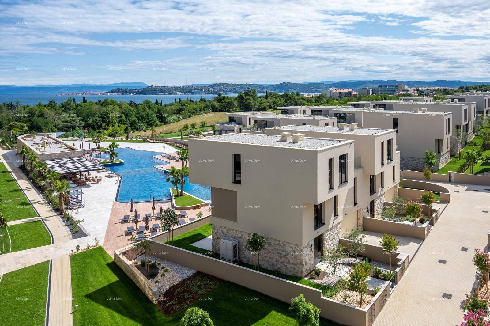 Luftaufnahme eines modernen Wohnkomplexes mit Poolbereich und Meerblick.