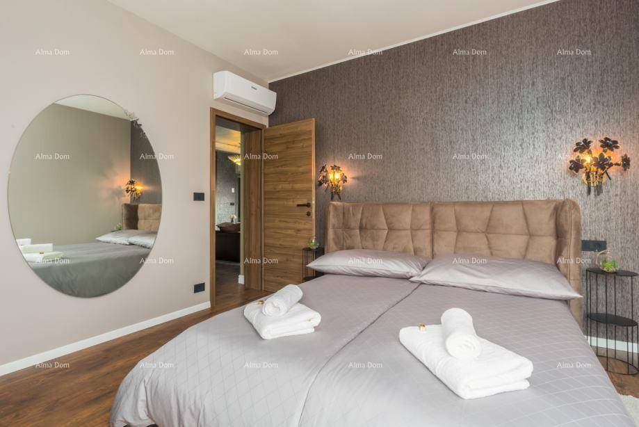 Gemütliches Schlafzimmer mit Doppelbett, großem runden Spiegel und Zugang zu einem angrenzenden Badezimmer.