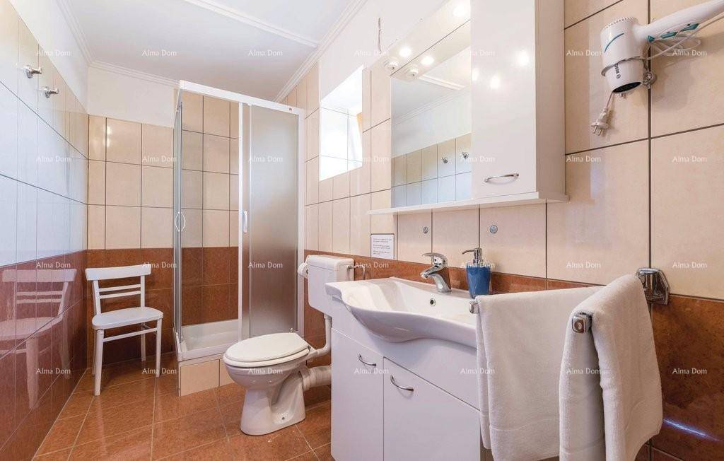 Funktionales Badezimmer mit Duschkabine, WC, Waschbecken und Fliesenboden.
