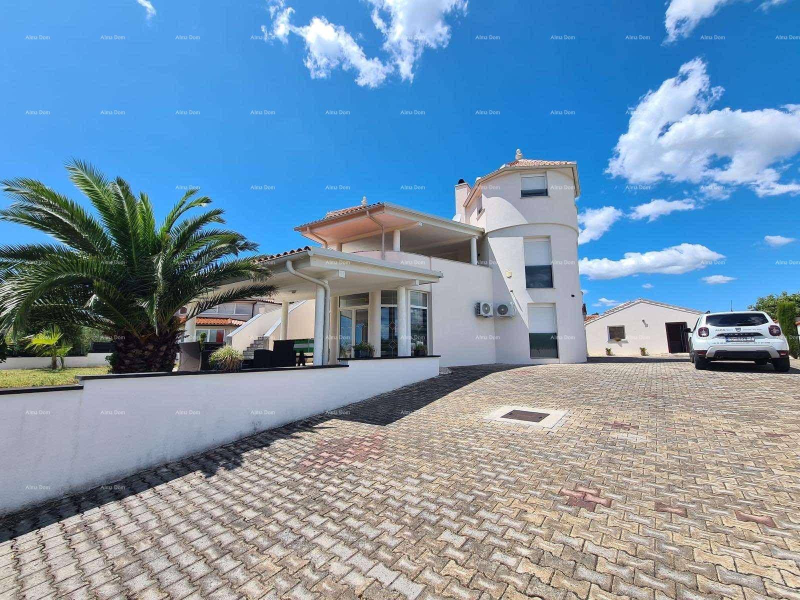 Ansicht der modernen Villa mit gepflasterter Auffahrt, Palmen und klarem blauen Himmel.