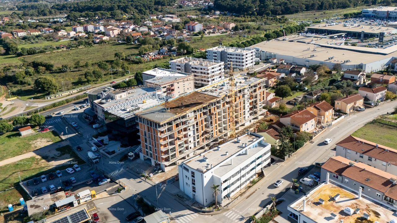 Luftaufnahme einer Baustelle in städtischer Umgebung mit angrenzenden Grünflächen und Straßen.