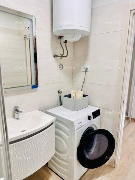 Badezimmer mit Waschbecken, Waschmaschine und Warmwasserboiler an der Wand.