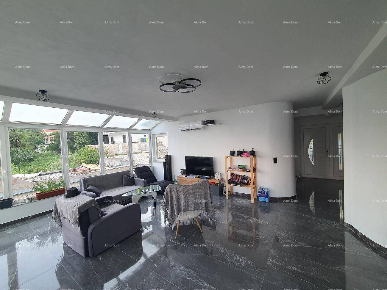 Helles Wohnzimmer mit großen Glasfenstern und dunklen Fliesen, ausgestattet mit Klimaanlage.