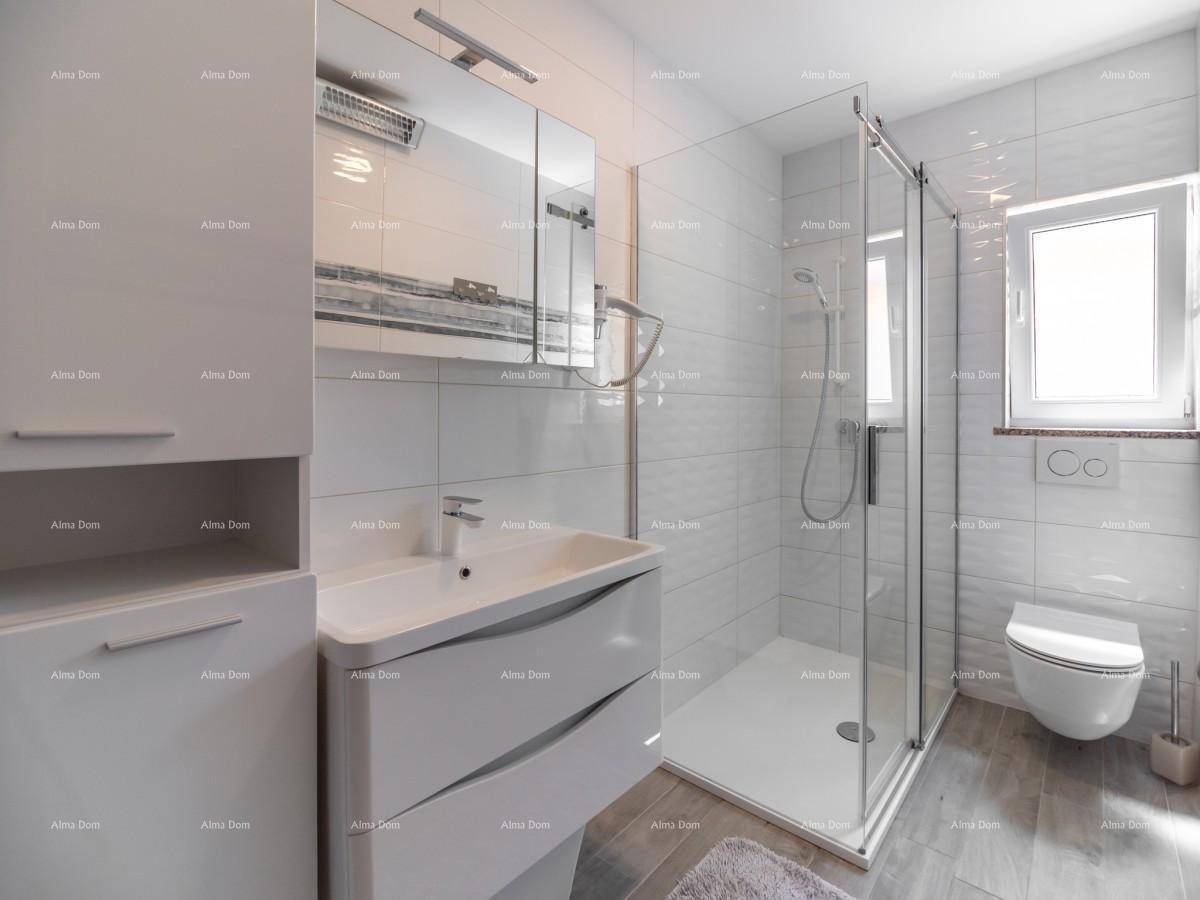 Modernes Badezimmer mit begehbarer Dusche, wandhängendem WC und großformatigen weißen Fliesen.