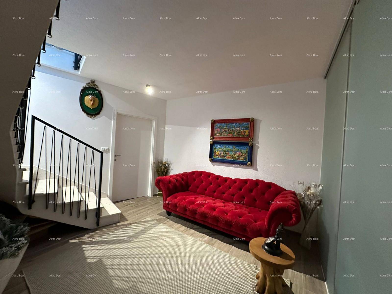 Heller Flurbereich mit rotem Sofa, Treppe und natürlichem Licht durch ein Oberlicht.