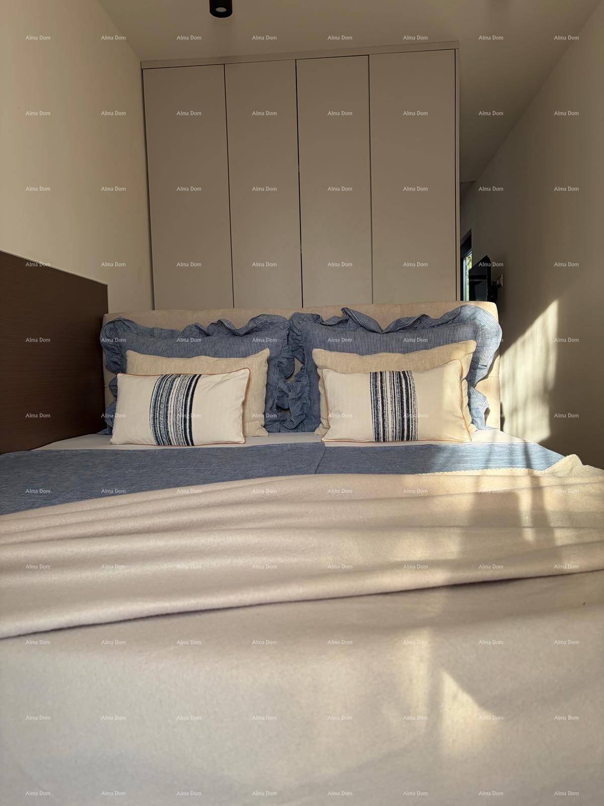 Helles Schlafzimmer mit großem Bett, Einbauschränken und Holzboden, durchflutet von Sonnenlicht.