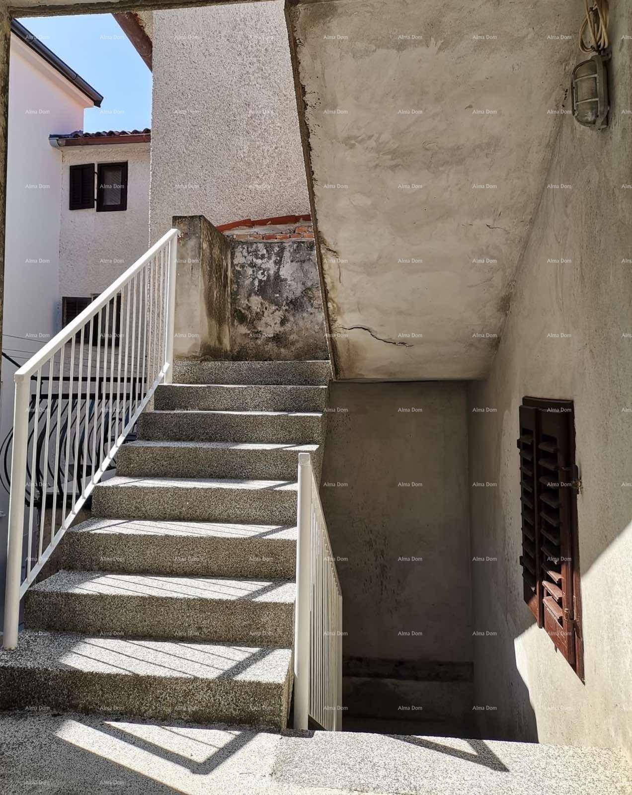 Außenansicht eines Gebäudes mit Steintreppe und Fensterläden.