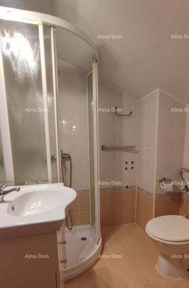 Badezimmer mit Duschkabine, Waschbecken und Toilette, in hellen Farbtönen.
