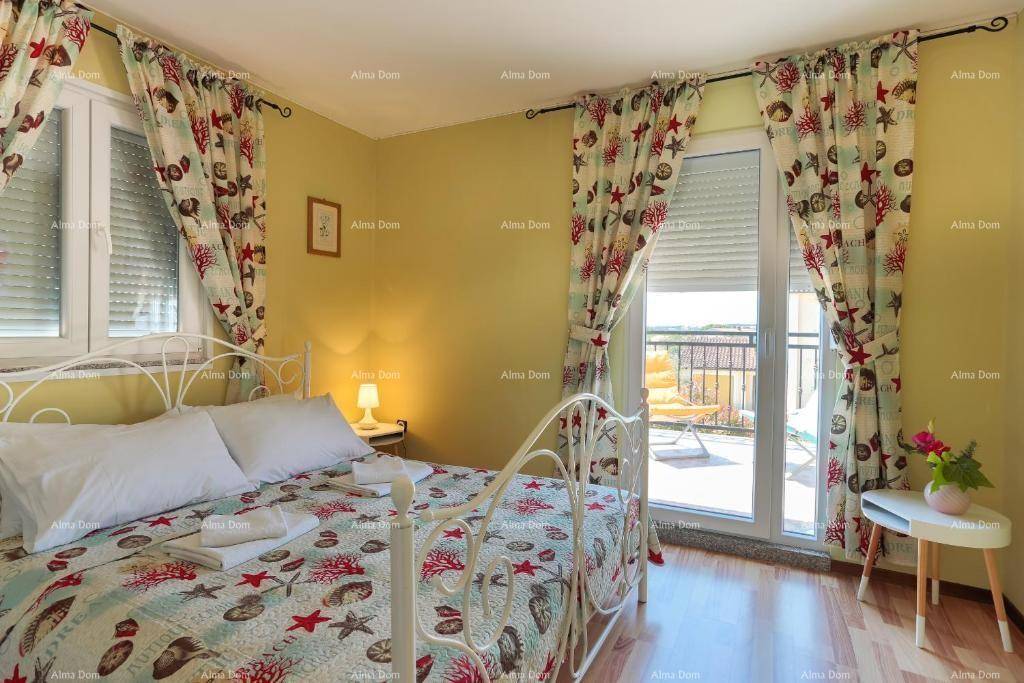 Helles Schlafzimmer mit Doppelbett, Holzboden und Zugang zu einem sonnigen Balkon.