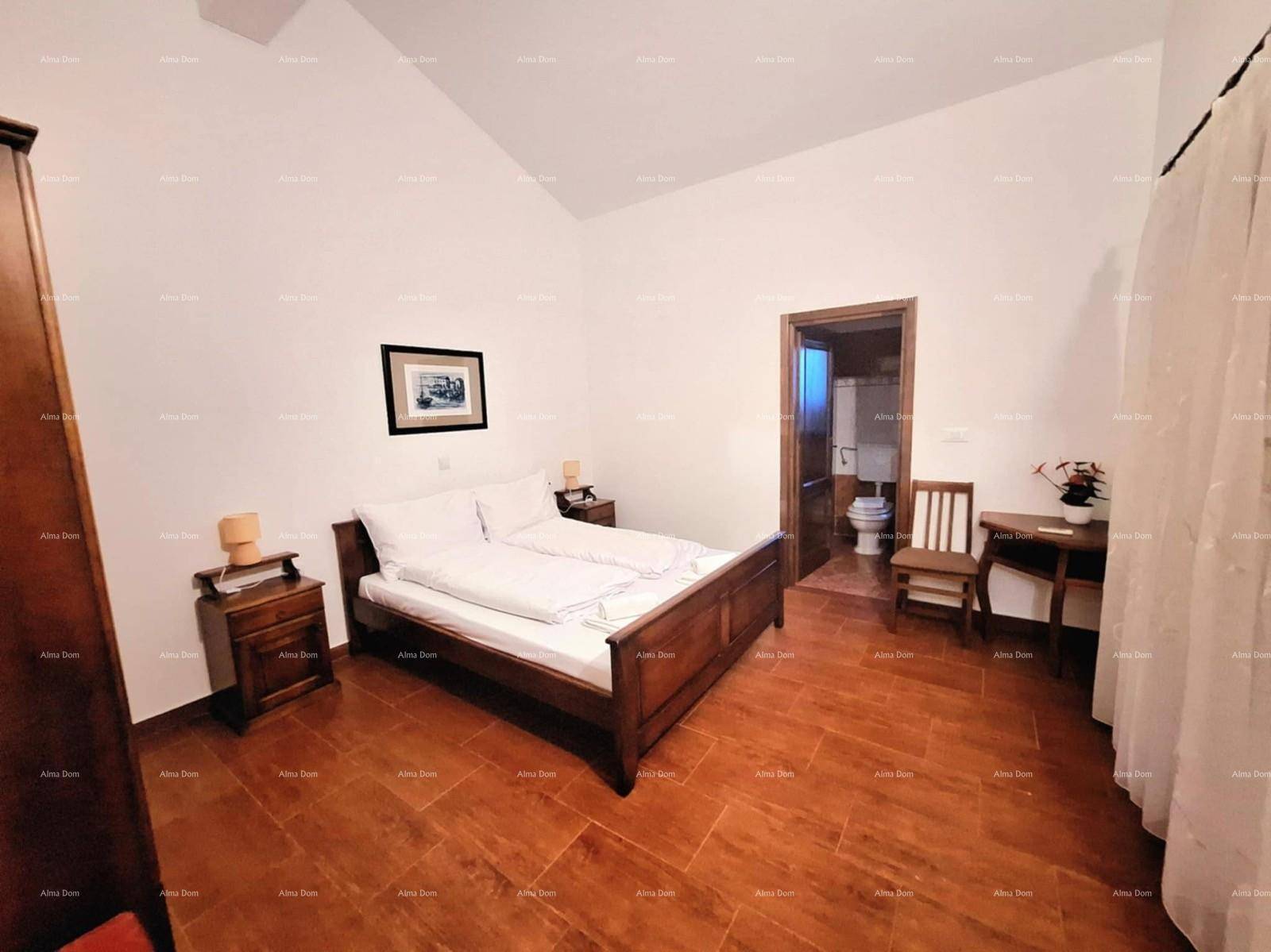 Helles Schlafzimmer mit Doppelbett, Holzmöbeln und direktem Zugang zum Badezimmer.