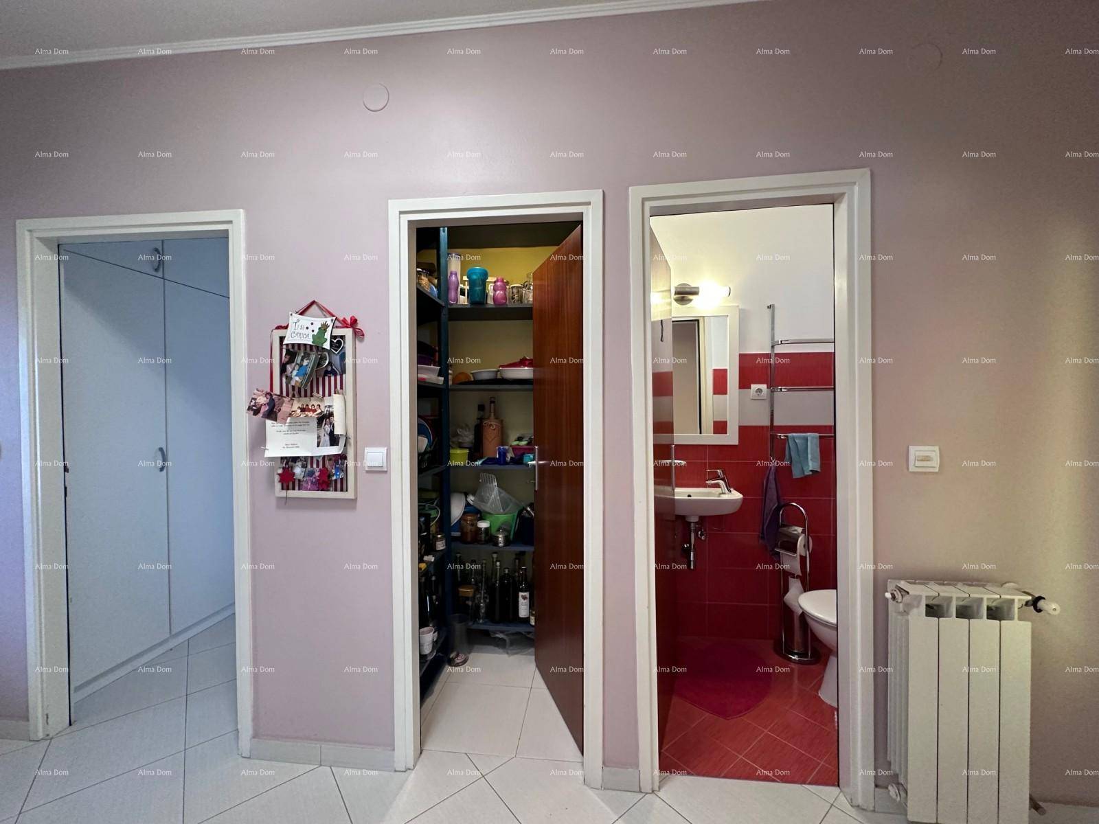 Flurbereich mit offener Abstellnische und Zugang zum rot gefliesten Badezimmer.