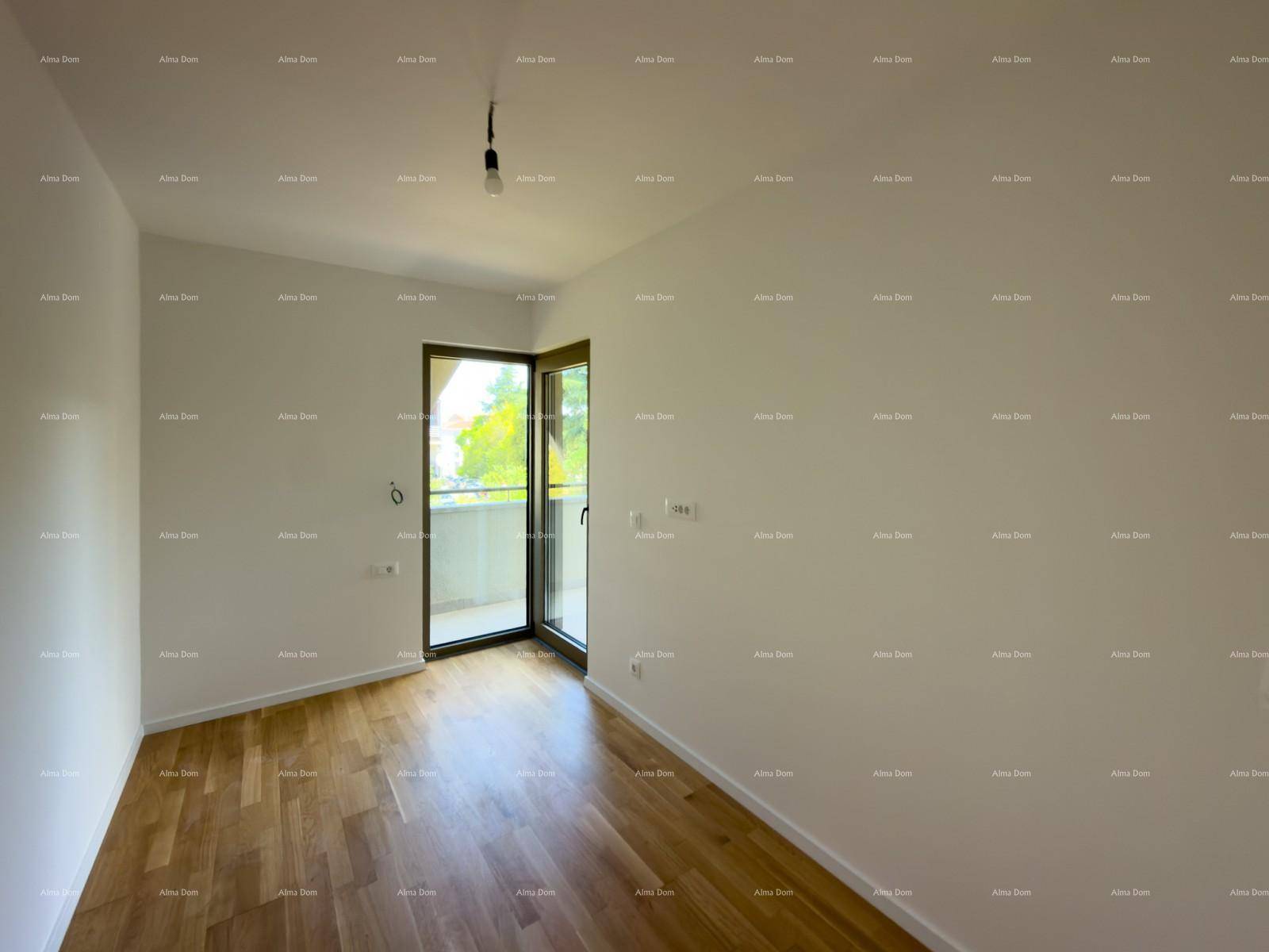 Helles Zimmer mit Holzboden und Balkonzugang, bietet eine angenehme Aussicht ins Grüne.