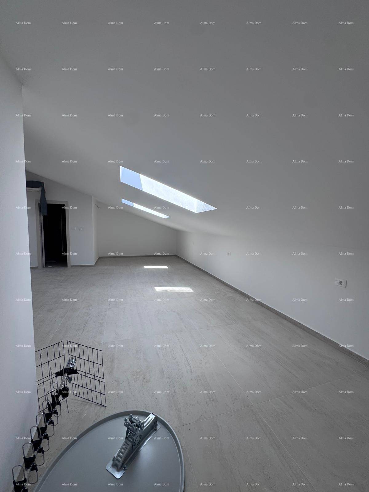 Geräumiger Dachbodenraum mit schrägen Decken, Fliesenboden und mehreren Dachfenstern.