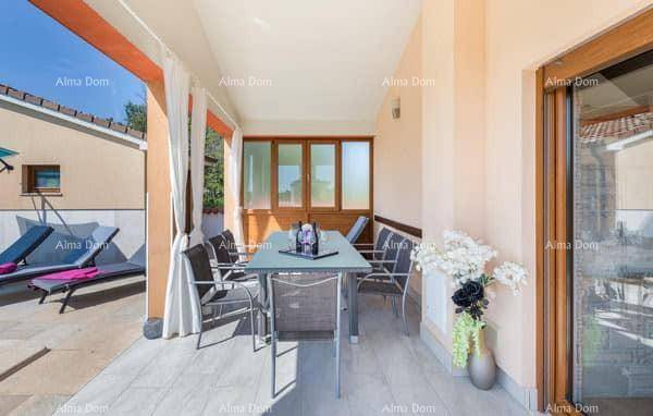 Überdachte Loggia mit Esstisch und Stühlen, ideal für Mahlzeiten im Freien mit Blick auf den Poolbereich.