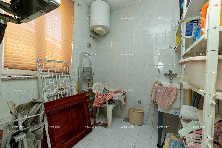 Praktischer Hauswirtschaftsraum mit Boiler, Waschbecken und Regalen für Vorräte.