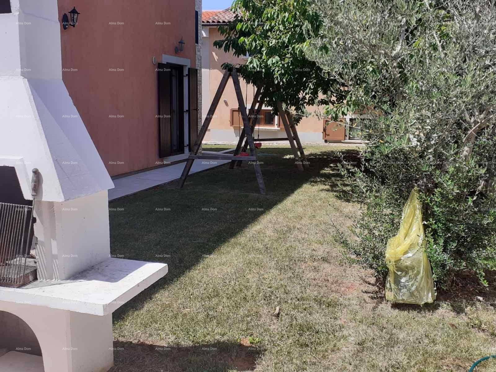 Grüner Gartenbereich mit Schaukel und gemauertem Grill, umgeben von Bäumen.