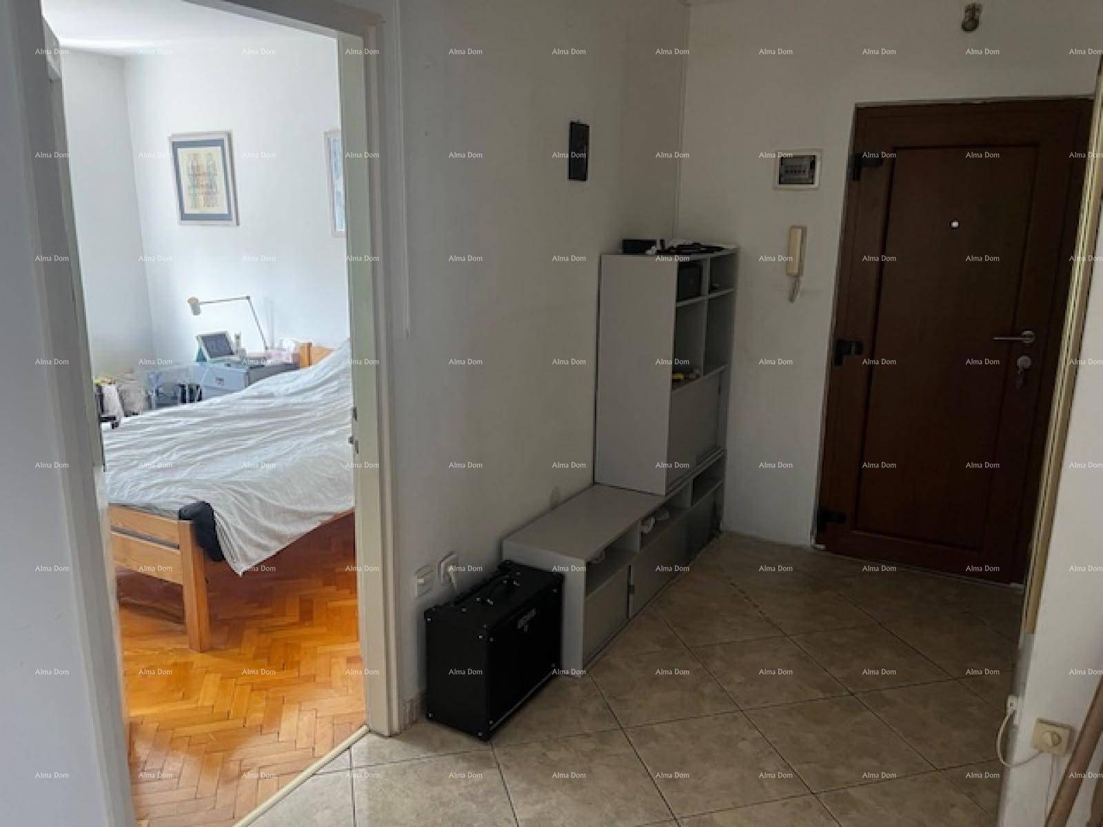 Eingangsbereich mit Fliesenboden, Garderobe und Blick in ein angrenzendes Schlafzimmer.