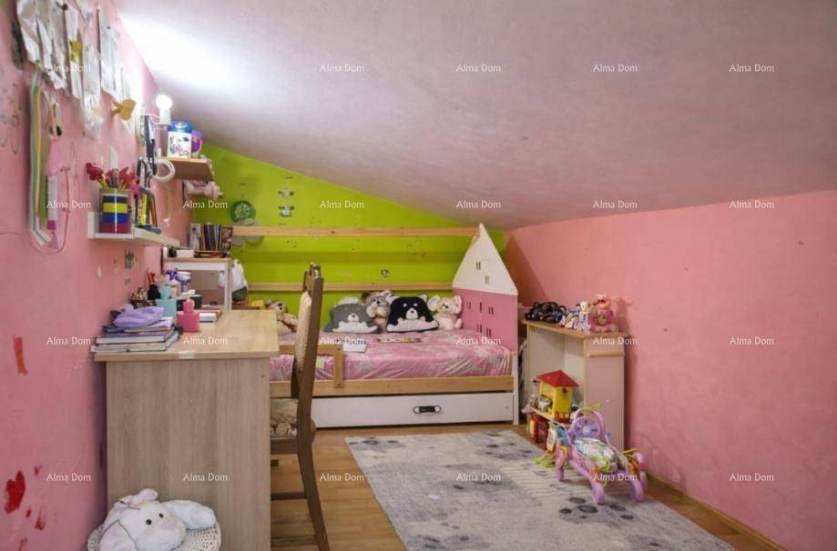 Farbenfrohes Kinderzimmer im Dachgeschoss mit Schreibtisch, Bett und schrägen Wänden.