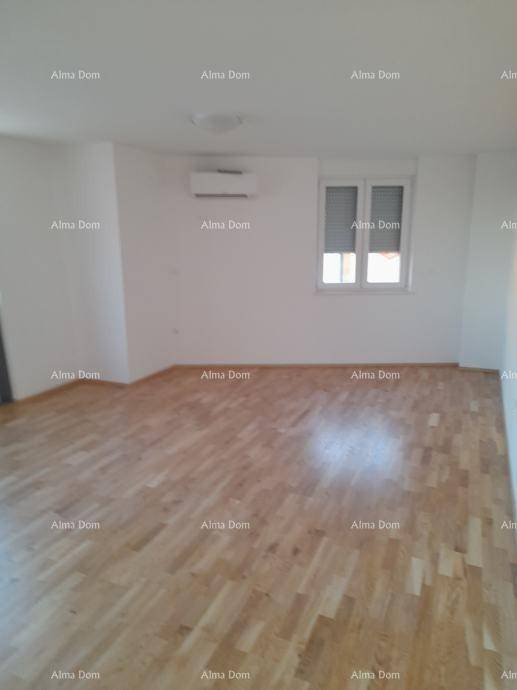 Geräumiger Raum mit Holzboden, Klimaanlage und Fenster mit Rollladen, ideal als Wohn- oder Schlafzimmer.