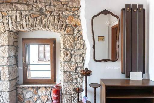 Rustikaler Flur mit Steinwand, Fenster und dekorativem Spiegel, bietet einen traditionellen Empfang.