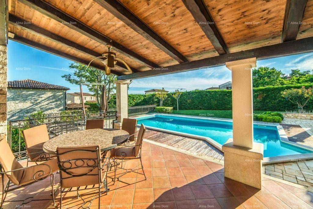 Überdachter Essbereich auf der Terrasse mit Blick auf den Pool und die grüne Hecke.