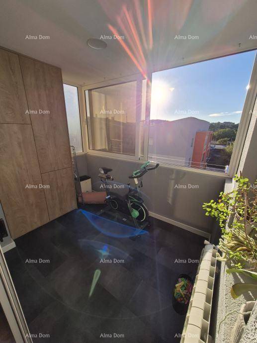 Sonnige, verglaste Loggia mit Trainingsgerät und weitem Blick, perfekt für Sport und Entspannung.