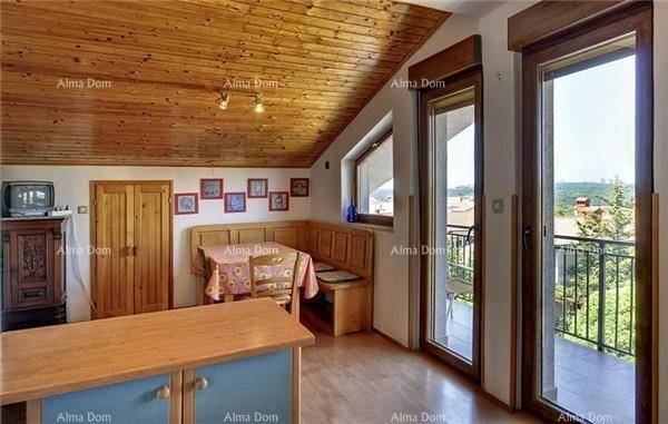 Wohn-Essbereich mit Holzbalkendecke, Holzboden und Zugang zu einem kleinen Balkon.
