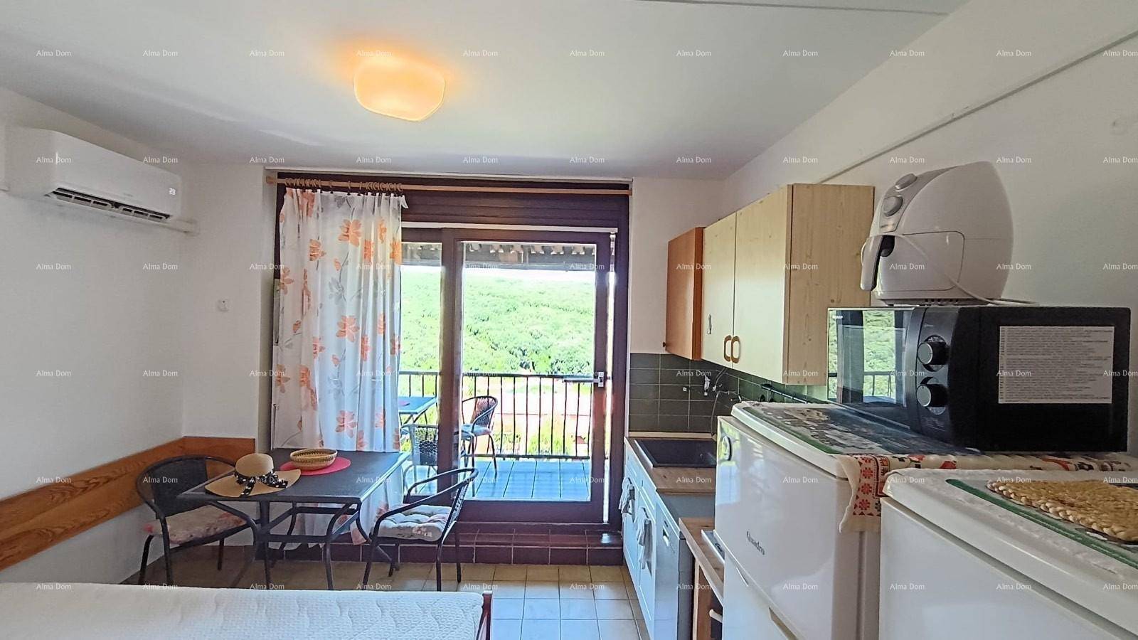 Heller Wohnbereich mit Küchenzeile und Esstisch, direkter Zugang zum Balkon mit Weitblick.