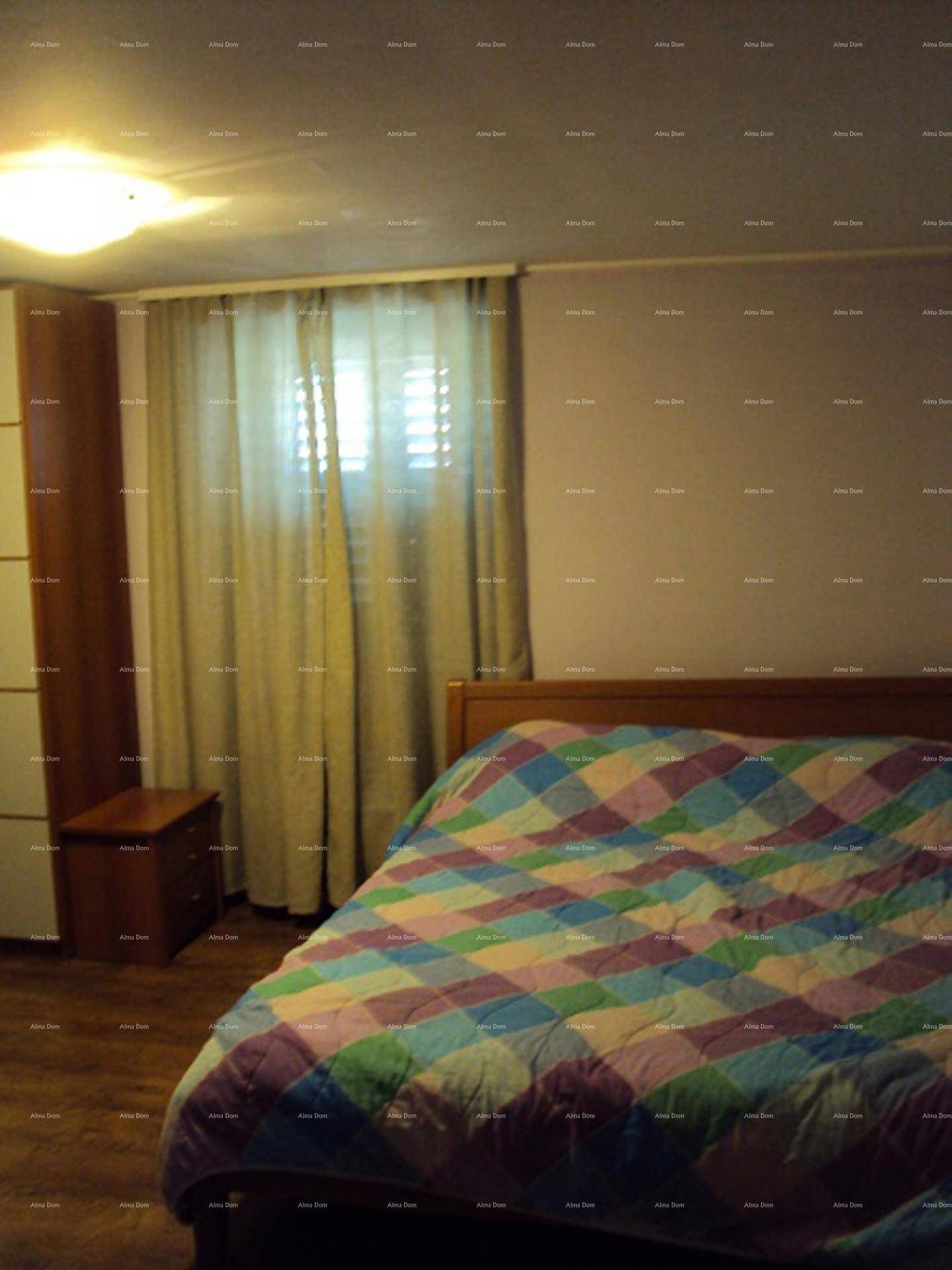 Schlafzimmer mit Bett, Nachttisch und einem Kleiderschrank, ausgestattet mit Holzboden.