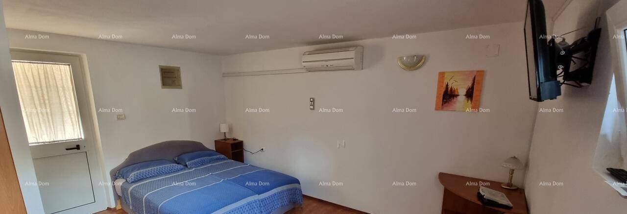 Schlafzimmer mit Doppelbett, Klimaanlage und Fernseher an der Wand.