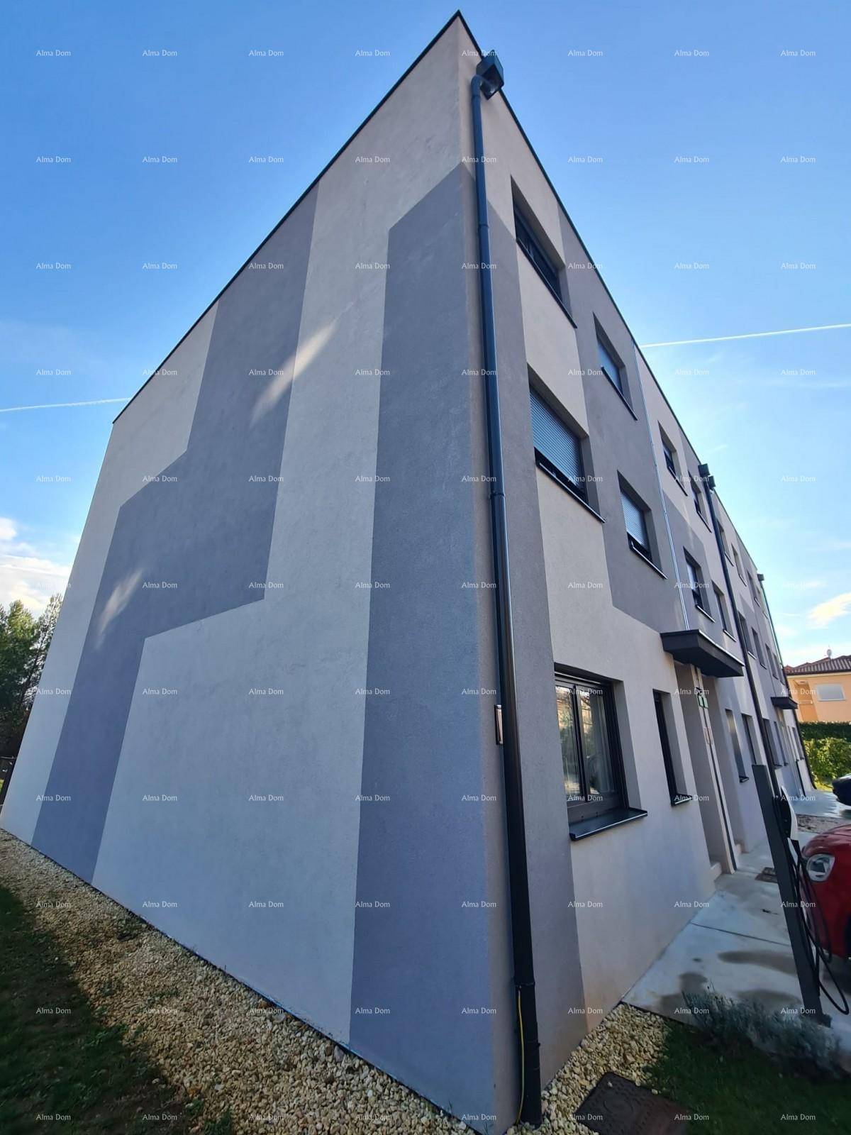 Seitenansicht eines modernen Gebäudes mit grauer Fassade und klaren architektonischen Linien.