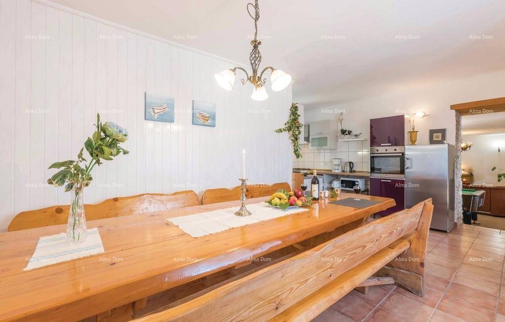 Rustikaler Essbereich mit langem Holztisch und Bänken, angrenzend an die Küche.