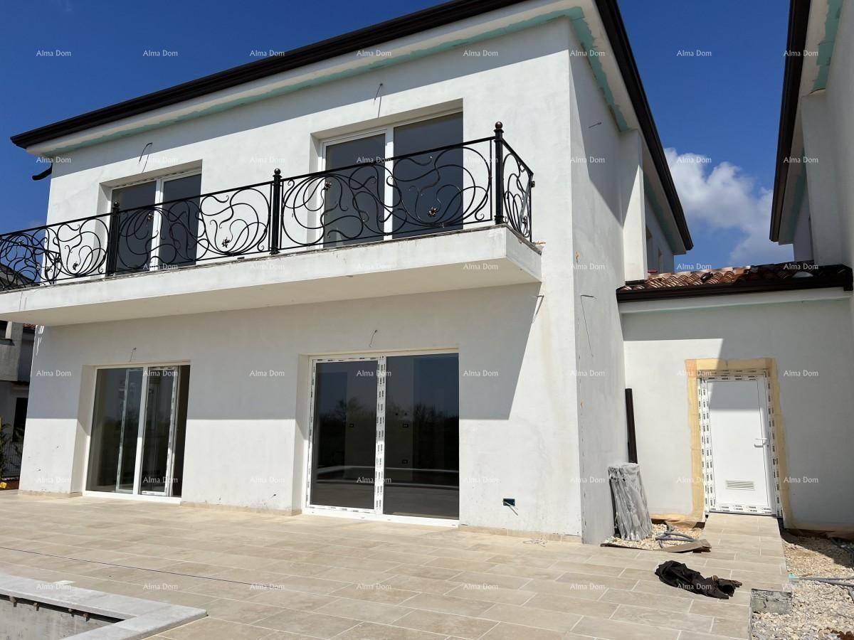 Große geflieste Terrasse mit Zugang zum Haus und Balkon mit schmiedeeisernem Geländer.