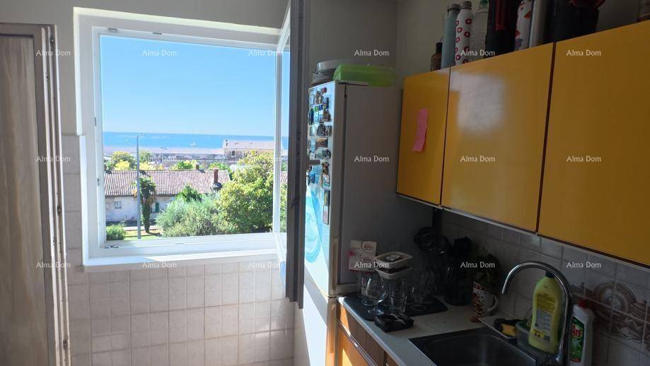 Helle Küche mit gelben Schränken und Fenster mit direktem Meerblick.