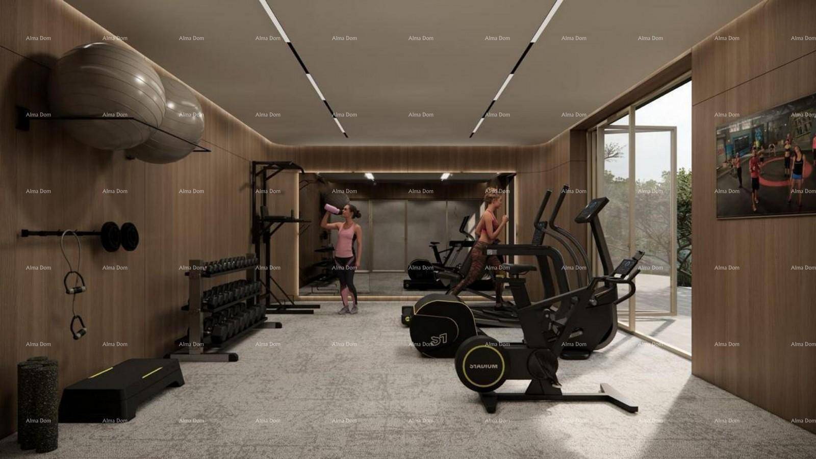 Moderner Fitnessraum mit verschiedenen Trainingsgeräten und Holzverkleidung.